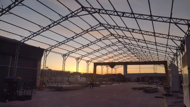 Estrutura treliçada de galpão concluída ao pôr do sol